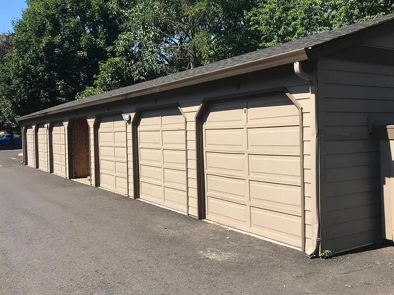 Before: A row of garage doors replaced in dark brown