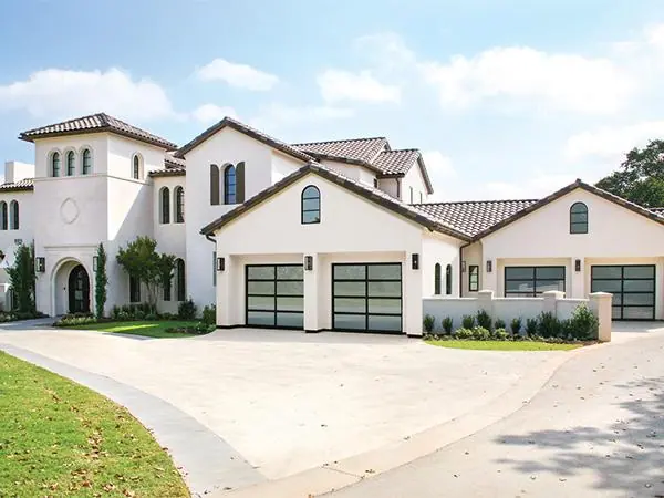 Black framed glass garage doors on a white stucco home